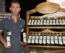 ÖREN MEYDANINDA ÖDÜLLÜ YAĞLARINI TANITIYOR Balıkesir’in Burhaniye ilçesinde, Zeytin Dostu Derneği’nin düzenlediği yarışmada, erken hasat