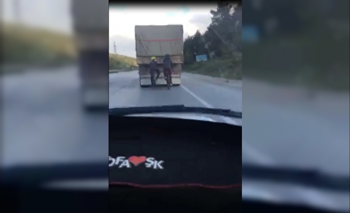 Bursa’da iki bisiklet sürücüsünün önlerinde giden kamyonun arkasına tutunarak yolculuk